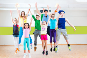 Dance teacher giving children Zumba fitness class in gym